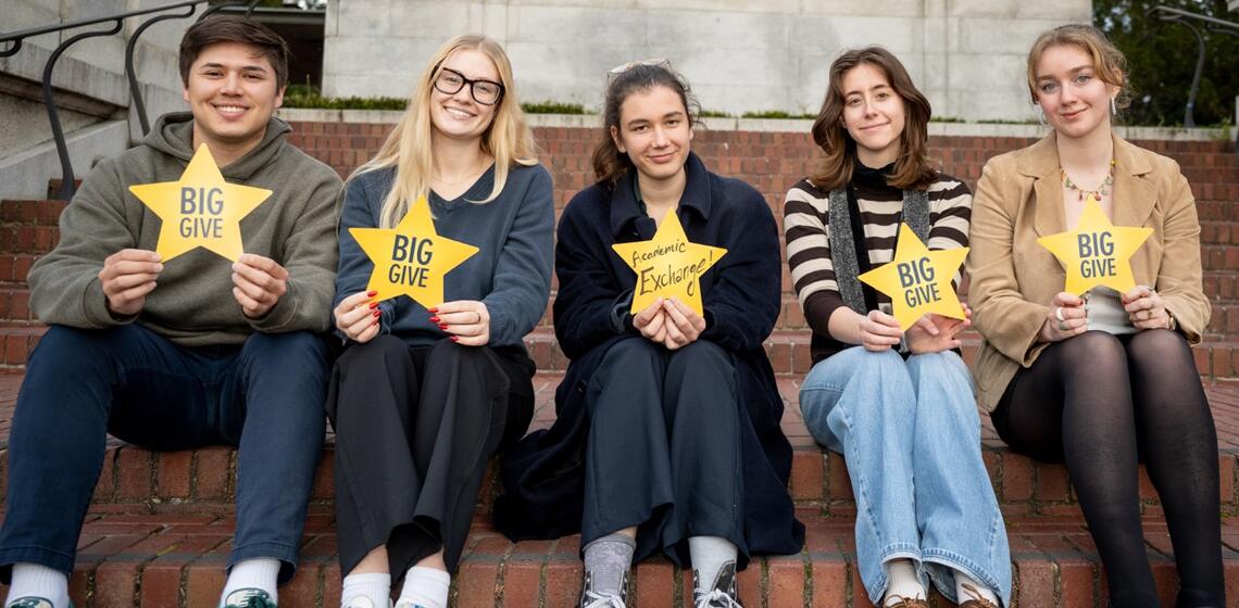 URAP students stand on the balcony by Philosophy Hall holding yellow stars
