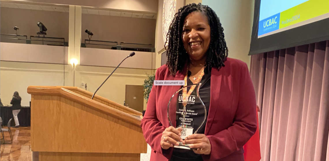 IES Administrative Director Gia White holds the 2024 Walter A. Robinson Excellence in Service Award at UCBAC