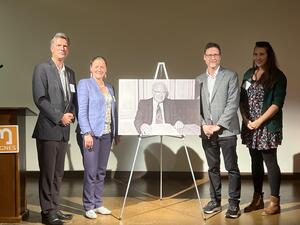 Jeroen Dewulf, Isabella Tomas, Paul Lerner, and Viola Alianov-Rautenberg pose in front of a picture of Gerald Feldman